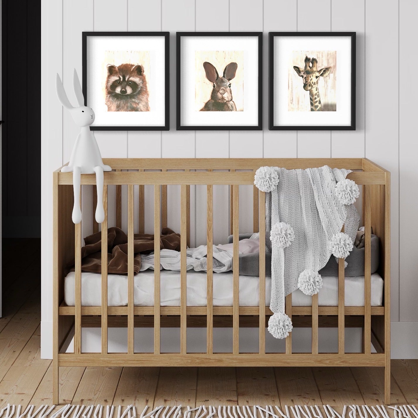 Crib with 3 nursery images above it. 
