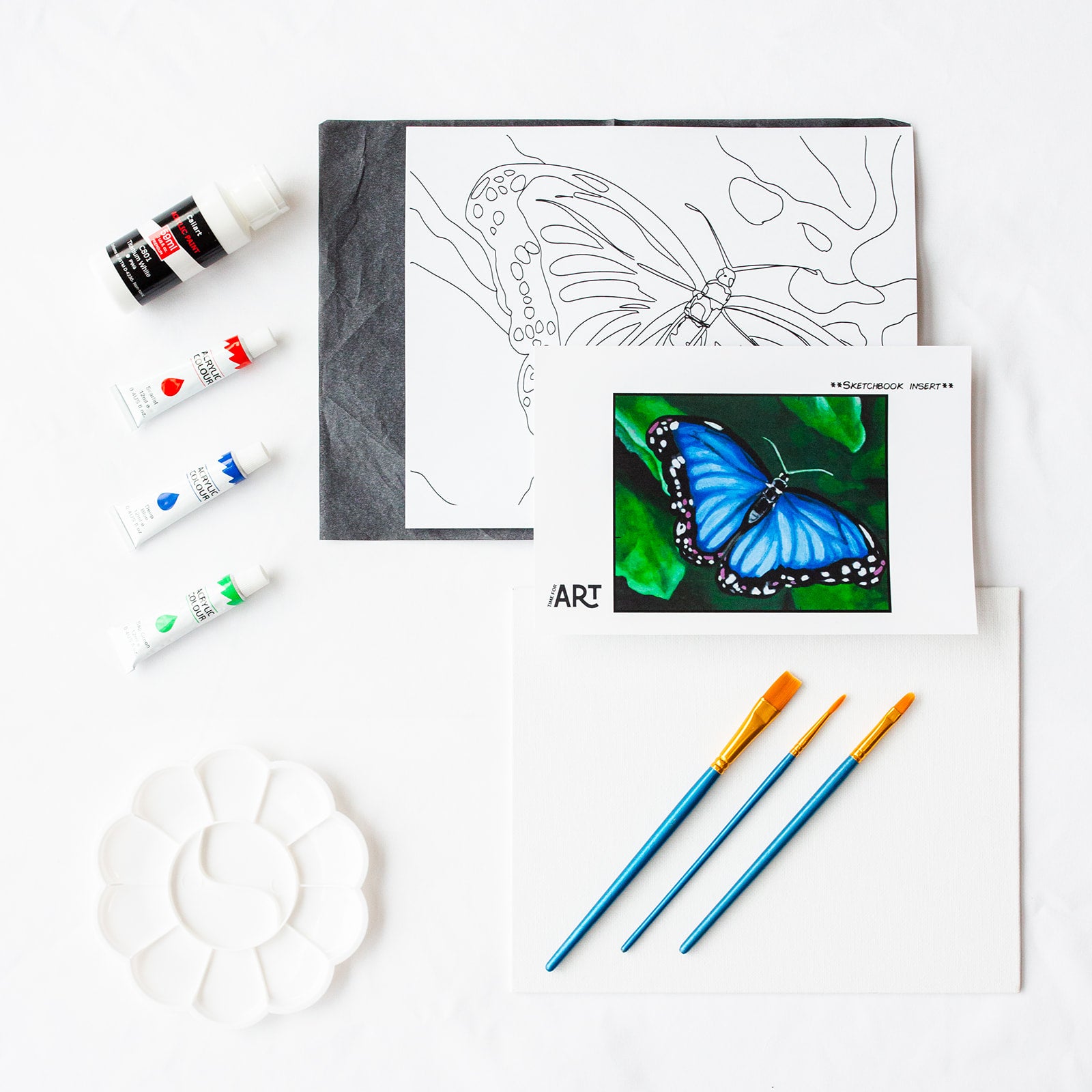 A picture of what is included in the Time For Art Blue Butterfly Painting Kit. The DIY Kit comes with 4 paints, a palette, the outline, brushes, canvas and more! 