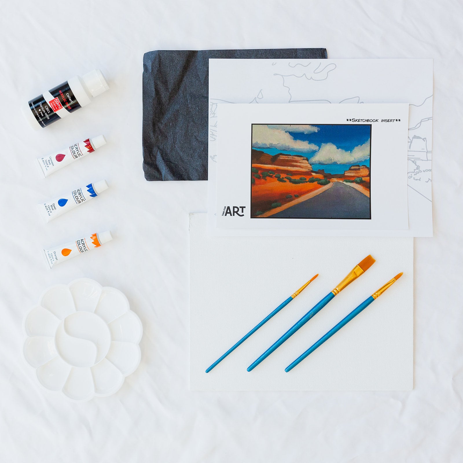 A picture of what is included in the Time For Art Desert Road Painting Kit. The DIY Kit comes with 4 paints, a palette, the outline, brushes, canvas and more! 