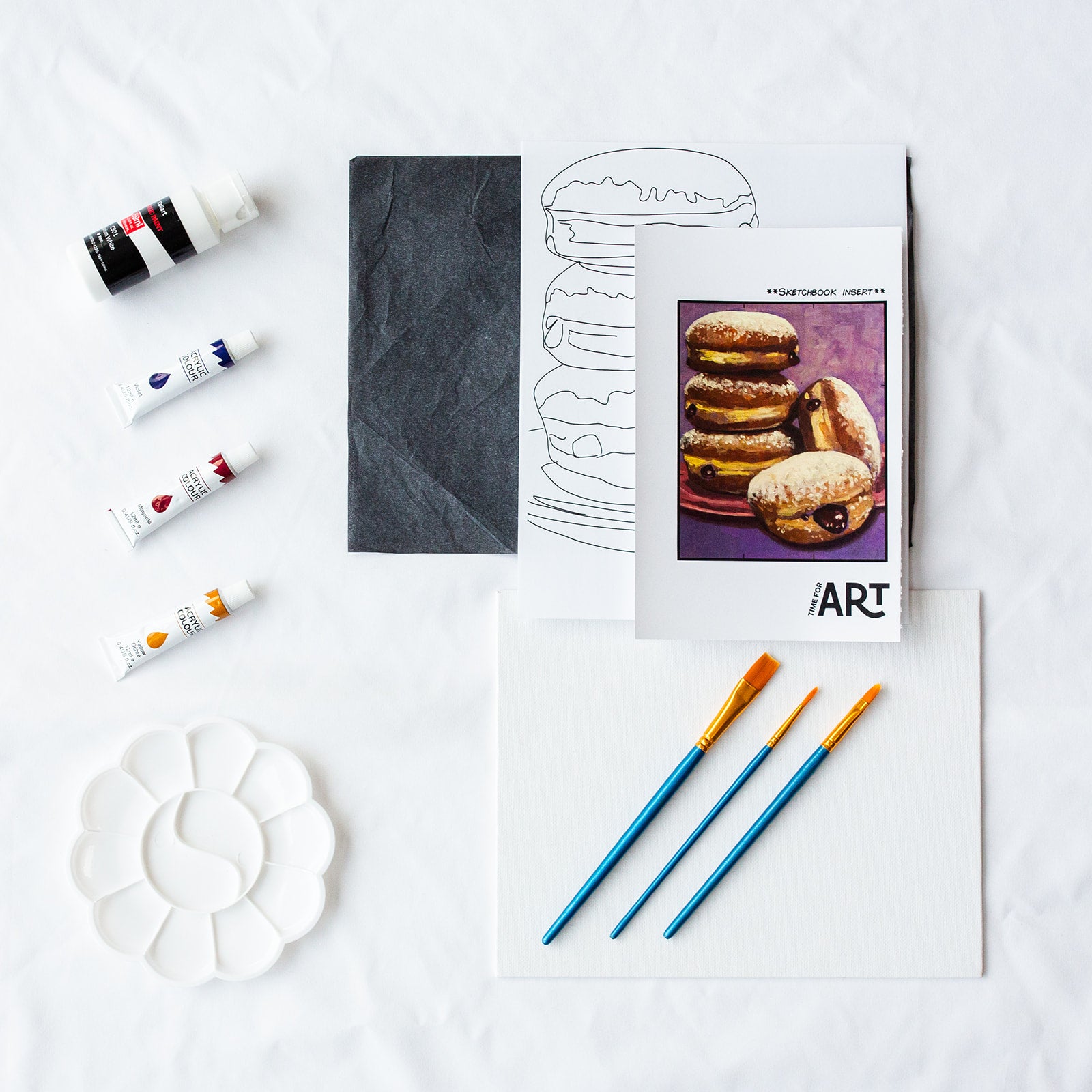 A picture of what is included in the Time For Art Jelly Donuts Painting Painting Kit. The DIY Kit comes with 4 paints, a palette, the outline, brushes, canvas and more! 