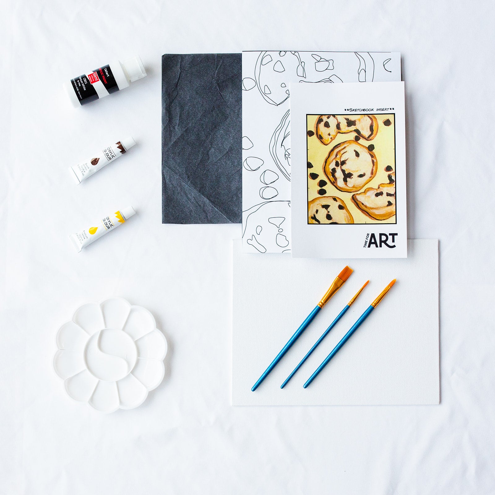 A picture of what is included in the Time For Art Cookie Cravings Painting Kit. The DIY Kit comes with 3 paints, a palette, the outline, brushes, canvas and more! 